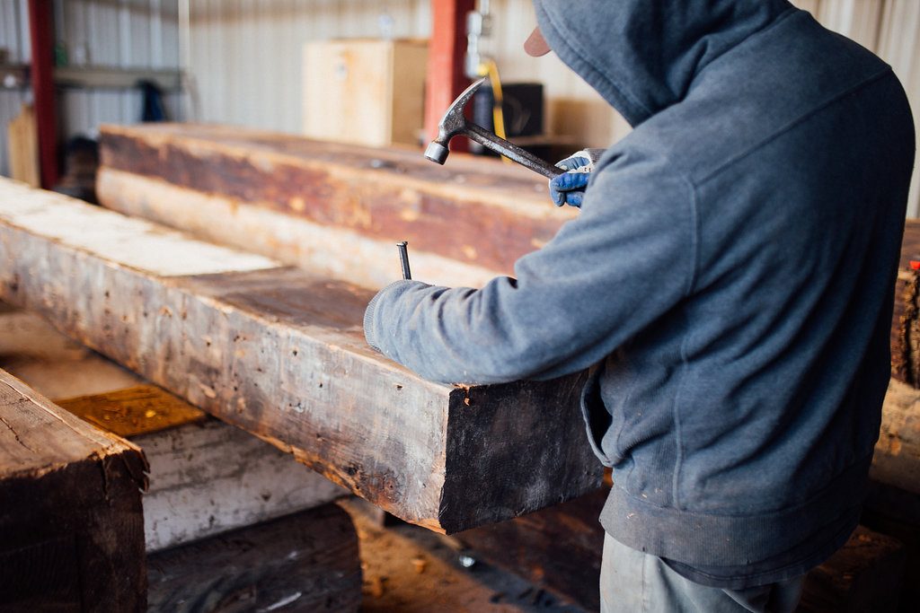 Cleaning reclaimed barn beams for custom flooring by Cochran's Lumber Made in USA